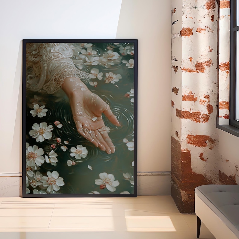 May include: A hand reaches out from a pool of water, surrounded by white flower petals. The water is a deep green color and the hand is pale with long, slender fingers.