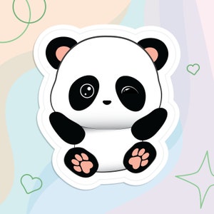 May include: A white and black cartoon panda bear with pink ears and paws. The panda is sitting with its arms crossed and has a cute expression on its face.