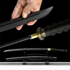 May include: A black katana sword with a curved blade, featuring a black handle wrapped in black fabric. The sword has a gold-colored guard and is displayed on a black stand. The blade is being held by a hand.