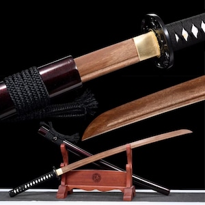 May include: A traditional Japanese katana sword with a wooden scabbard and a black and white patterned handle. The sword is displayed on a wooden stand.