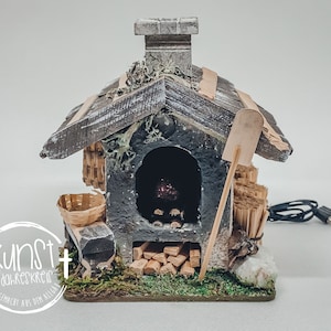 Peut inclure: Un petit modèle en bois d'un four à bois avec une cheminée, une pelle, un panier et une pile de bûches. Le four est allumé et brille d'une couleur orange. Le modèle est fait de bois, de métal et de tissu.
