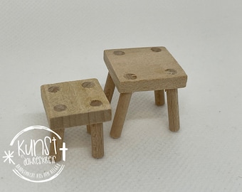 Puede incluir: Dos taburetes de madera, uno más grande que el otro, ambos con un diseño simple y cuadrado. Los taburetes están hechos de madera marrón claro y tienen un acabado natural.