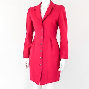 May include: A bright red button-up dress with a fitted bodice and a slightly flared skirt.