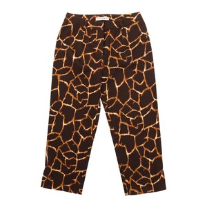 May include: Brown and tan giraffe print trousers. The trousers have a high waist and a straight leg. The fabric features a pattern of brown shapes with tan outlines. The trousers are made of a lightweight material.