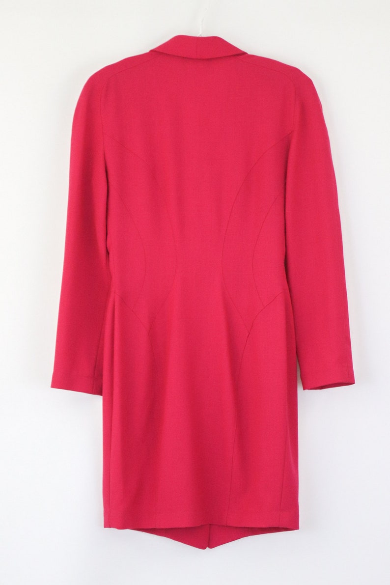 May include: A bright pink blazer with a long sleeve and a fitted silhouette.