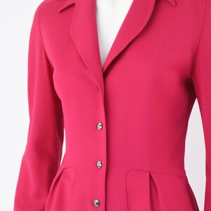 May include: A long-sleeved, pink dress with a collared neckline and button closure. The dress has a fitted bodice and a slightly flared skirt.