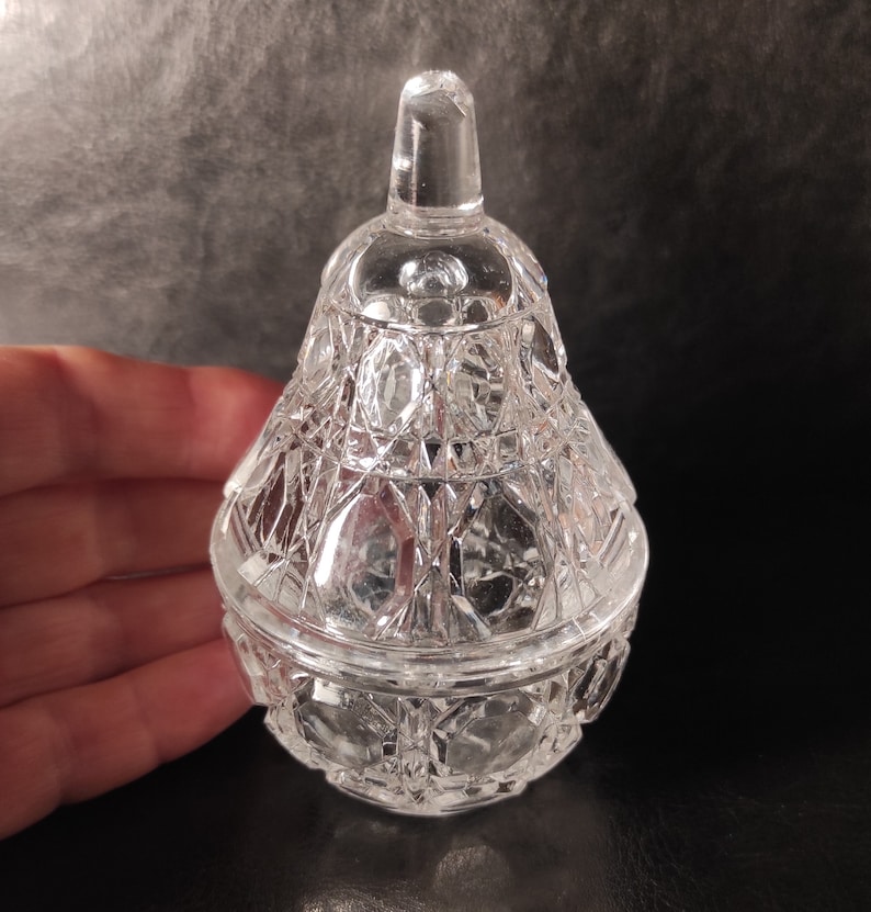 Pu&ograve; includere: Una scatola portaoggetti in vetro trasparente a forma di pera con un design in vetro tagliato. Il coperchio &egrave; anch'esso in vetro tagliato e ha una parte superiore appuntita.