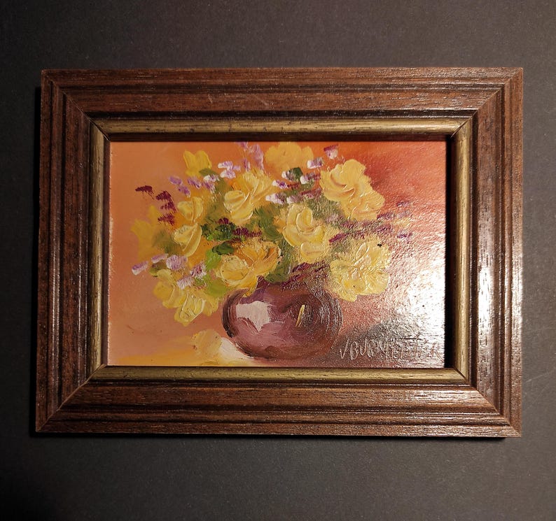 May include: A framed painting depicting a still life with a bunch of yellow roses in a purple vase. The background is a warm orange colour.