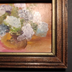 May include: A framed oil painting of a bouquet of purple and blue flowers in a brown vase. The painting is signed "V. Bunny" in the lower right corner.