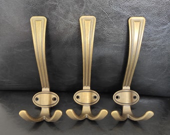 Set of 3 vintage brass plated metal coat hooks. Hooks with brass coating for hanging in the hallway.