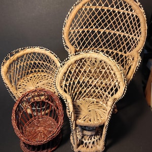 以下が含まれることがあります： さまざまなサイズと茶色の濃淡の、4つのミニチュア織り籐椅子。椅子は、丸みを帯びた背もたれと織り込まれた座面を備えた孔雀の椅子のデザインです。1つの椅子は濃い赤茶色で、他の椅子は明るいタン色です。