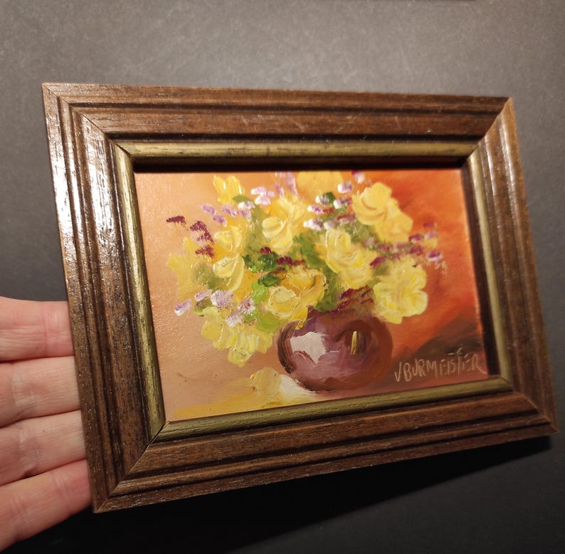 May include: A framed painting of a yellow flower bouquet in a purple vase. The painting is signed "J. Burmeister".