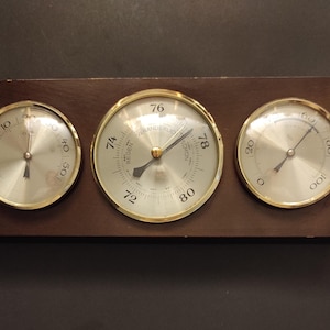 Vintage room thermometer, barometer and humidity meter/ Old wall-mounted indoor weather station in a wooden frame