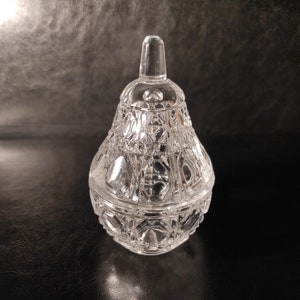 Pu&ograve; includere: Un vaso di vetro trasparente a forma di pera con un coperchio. Il vaso ha un design in vetro tagliato.