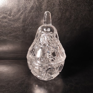 Pu&ograve; includere: Un vaso di vetro trasparente a forma di pera con un coperchio. Il vaso ha un design in vetro tagliato ed &egrave; perfetto per riporre piccoli oggetti.