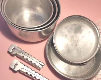Vintage pots and pans — a set of antique aluminum cookware in various sizes, for a collection or for decorating a kitchen, patio, farmhouse