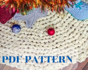 Könnte beinhalten: Weißer gestrickter Weihnachtsbaumrock mit einem roten und blauen Ornament oben. Der Text "PDF PATTERN" ist auf dem Rock gedruckt.