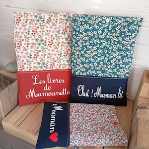 May include: Several fabric book covers with floral patterns and text. One cover has a red base with the text "Les livres de Mamounette". Another has a teal base with the text "Chut! Maman lit". A smaller cover has the word "Maman" and a heart.
