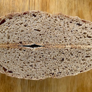 May include: A close-up of a sliced loaf of brown bread, showing the crumb texture and air pockets.
