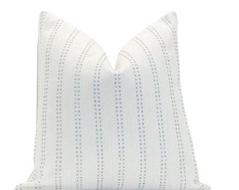 May include: White throw pillow with a subtle blue and white striped pattern. The pattern is made up of small dots that create a subtle stripe effect.