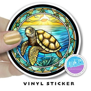 May include: A round vinyl sticker featuring a stained glass style illustration of a sea turtle swimming in the ocean with a sunset in the background.