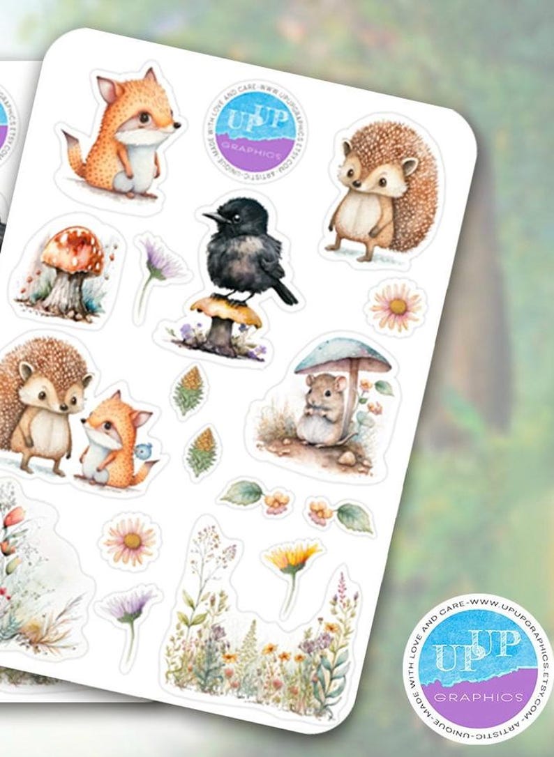 Puede incluir: Una hoja de pegatinas caprichosas con criaturas del bosque y elementos florales. Las pegatinas incluyen un zorro, un erizo, un p&aacute;jaro, una seta y un rat&oacute;n, todos en estilo acuarela. Las pegatinas est&aacute;n sobre un fondo blanco con un logotipo en la esquina.