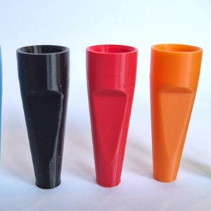 K&ouml;nnte beinhalten: F&uuml;nf farbige Kunststofftrichter in einer Reihe. Die Trichter sind in Blau, Schwarz, Rot, Orange und Gr&uuml;n gehalten. Jeder Trichter hat eine breite &Ouml;ffnung und einen abgeschr&auml;gten Ausguss.