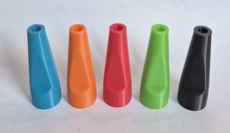 K&ouml;nnte beinhalten: F&uuml;nf farbige, konisch geformte Objekte in einer Reihe. Die Objekte sind in den Farbt&ouml;nen Blau, Orange, Rot, Gr&uuml;n und Schwarz gehalten. Jedes hat eine ausgeh&ouml;hlte Oberseite und eine flache, abgewinkelte Seite.