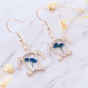 Pendientes colgantes de tortuga plateada con flores azules auténticas