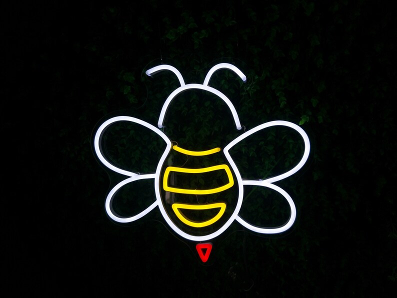 Puede incluir: Contorno de abeja de ne&oacute;n blanco con rayas amarillas y un aguij&oacute;n rojo. La abeja est&aacute; sobre un fondo verde oscuro.