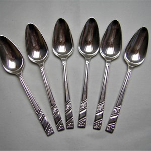 May include: Set of six silver teaspoons with ornate designs on the handles.