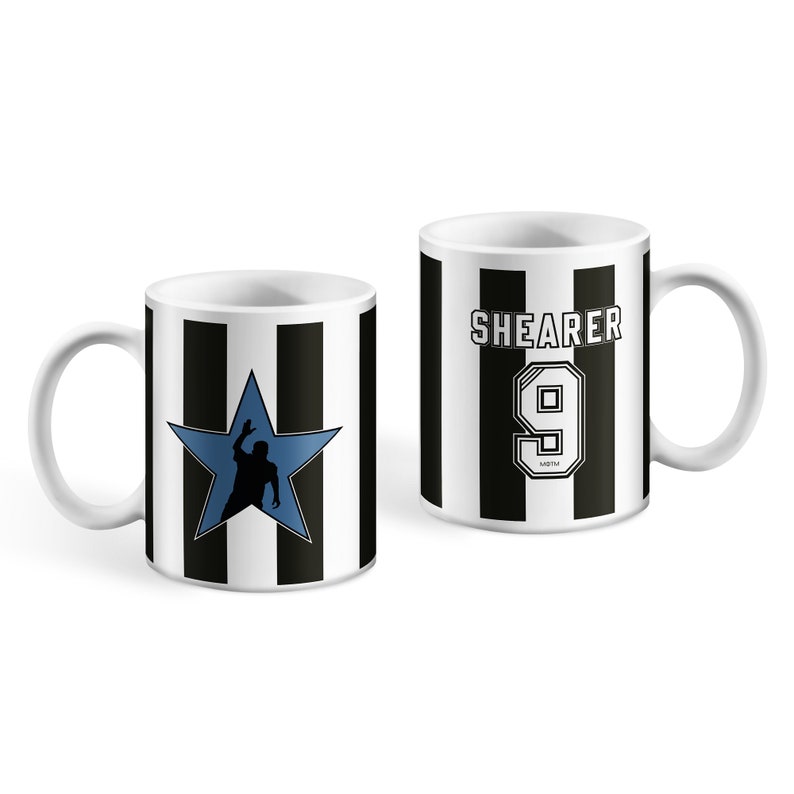 Puede incluir: Dos tazas de cer&aacute;mica blanca con rayas blancas y negras. Una taza presenta una estrella azul con la silueta de un jugador de f&uacute;tbol. La otra taza tiene el texto "SHEARER" y el n&uacute;mero "9" en negro.
