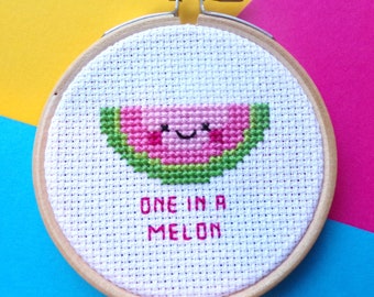 May include: A white embroidery hoop with a smiling watermelon design and the text "one in a melon".