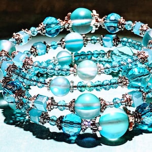 May include: A multi-strand bracelet with turquoise and silver beads. The bracelet is made of several strands of small turquoise beads, interspersed with larger turquoise beads and silver beads.