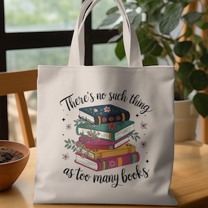 Op de afbeelding: Crèmekleurige draagtas met een stapel boeken en bloemmotieven. De tas heeft de tekst "There's no such thing as too many books". De tas heeft twee handvatten.