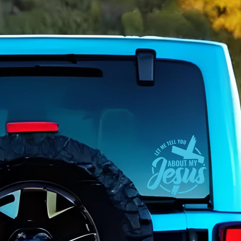 May include: A blue car with a white vinyl sticker on the back window. The sticker says "Let me tell you about my Jesus" with a cross graphic.