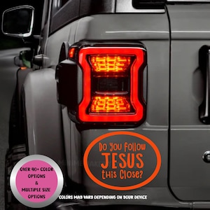 May include: A gray vehicle with a bright red taillight. An orange oval sticker on the vehicle reads "Do you follow JESUS this Close?" with additional text about color and size options.
