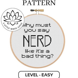May include: A white embroidery hoop with black text that reads "Why must you say NERD like it's a bad thing?"  The hoop is on a white background with the text "CROSS STITCH PATTERN" above the hoop and "LEVEL - EASY" below the hoop.  The text "A LITTLE WHITE LOTUS" is in a circle with a lotus flower design.