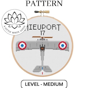 May include: Cross stitch pattern for a Nieuport 17 airplane, a vintage aircraft with red, white, and blue markings. The pattern is labeled as "medium" difficulty.