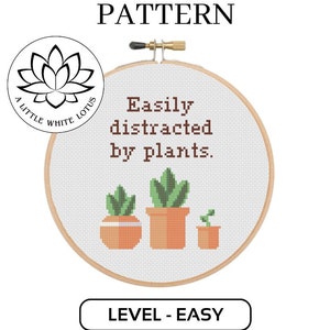 May include: Cross stitch pattern featuring a white embroidery hoop with the text "Easily distracted by plants." and three potted plants. The pattern is labeled "Level - Easy" and is a digital download product compatible with Pattern Keeper software.