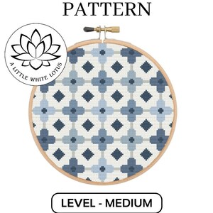 Pode incluir: Um padrão de ponto cruz com um design geométrico de quadrados e losangos azuis e brancos. O padrão é emoldurado em um aro de bordado de madeira. O texto "CROSS STITCH PATTERN" está na parte superior da imagem. O texto "LEVEL - MEDIUM" está na parte inferior da imagem. O texto "DIGITAL DOWNLOAD PRODUCT - COMPATIBLE WITH PATTERN KEEPER SOFTWARE" está na parte inferior da imagem.