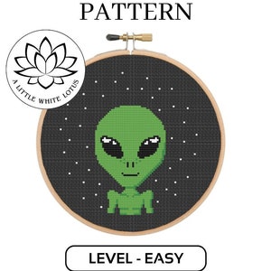 May include: Cross stitch pattern featuring a green alien with large eyes and a small mouth, against a black background with white stars. The pattern is labelled "Level - Easy" and is a digital download product compatible with Pattern Keeper software.