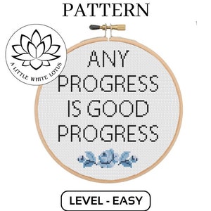 Puede incluir: Patrón de punto de cruz para un aro con el texto "Any progress is good progress" en texto negro. El aro está sobre un fondo blanco con un pequeño logotipo en la esquina superior izquierda. El patrón está etiquetado como "Nivel - Fácil".