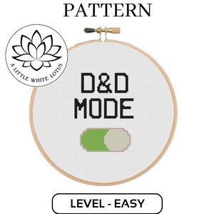 Może przedstawiać: Wzór na haft krzyżykowy do obręczy z białą tkaniną Aida i czarną nicią do haftu. Projekt zawiera tekst "D&D MODE" z zielonym i białym przełącznikiem. Wzór jest oznaczony jako "Poziom - Łatwy" i jest kompatybilny z oprogramowaniem Pattern Keeper.