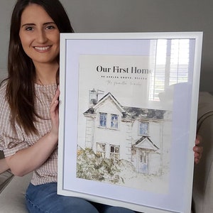 Könnte beinhalten: Ein weißer gerahmter Druck mit einer Aquarellillustration eines Hauses. Der Text "Our First Home" befindet sich oben auf dem Druck, gefolgt von der Adresse "88 Ashlea Grove, Killea" und dem Text "The [unleserlich] Family".