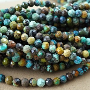 May include: A strand of turquoise gemstone beads with a faceted, irregular shape. The beads are a mix of blue, green, brown, and gold tones.