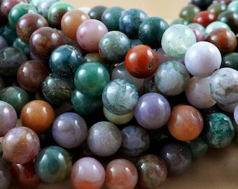 May include: A close-up of a variety of round, multi-colored agate beads. The beads are a mix of green, brown, purple, and red.