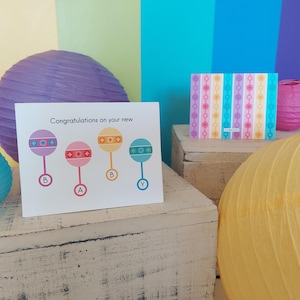 Nouvelle carte hochet pour bébé | Félicitations pour votre nouvelle carte de bébé | hochet pour bébé vintage | Carte de fête de naissance | Carte de voeux de bienvenue nouveau bébé