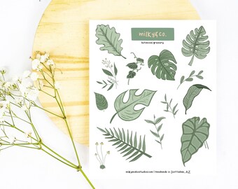 May include: A sheet of stickers featuring various green botanical illustrations, including leaves, ferns, and monstera plants. The stickers are labeled "milky co. botanical greenery".