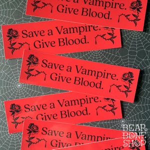 May include: Five red stickers with black text and a black rose graphic. The text on the stickers reads "Save a Vampire. Give Blood."